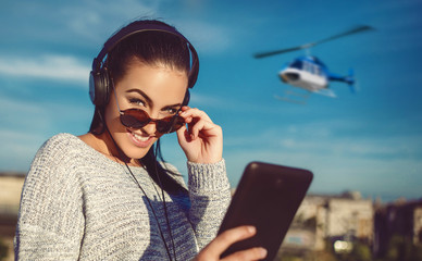 Young woman ordering helicopter tour ticket by tablet