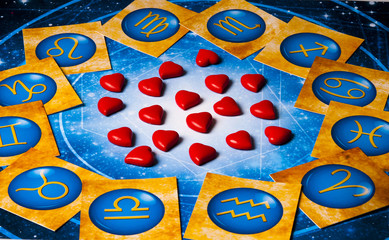 Wall Mural - astrology and love concept with red hearts lying on background with zodiac symbols