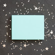 © goodmoments - rectangular light blue box on black background with silver stars decorations. Holiday greetings. Engagement. turquoise on black board.