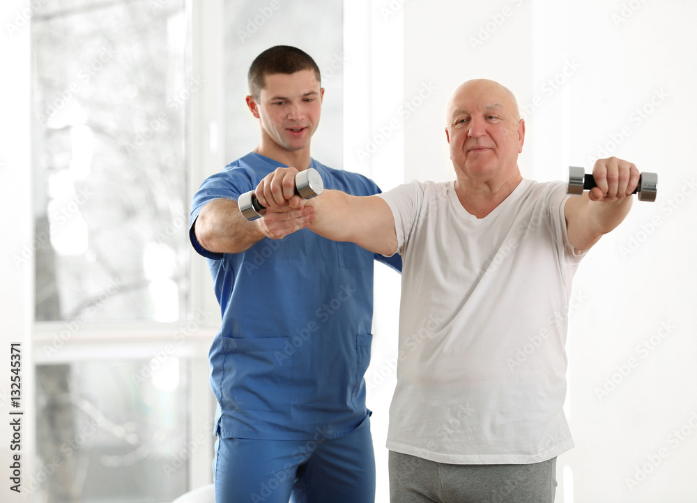 Physiotherapist working with elderly patient in clinic