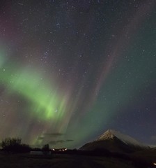 northern lights over snow capped mountain