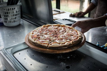 Wall Mural - Hands preparing a pizza  (dark background)