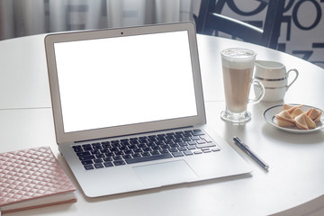 The laptop and a cup of coffee and cookies