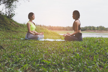 young woman meditates while practicing yoga outdoor in park,  re