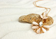 Golden jewellery pendant on sand beach, soft focus, macro