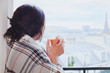 © Song_about_summer - woman drinking hot tea and looking at the window, cozy winter at home, warm up, december in city, waiting