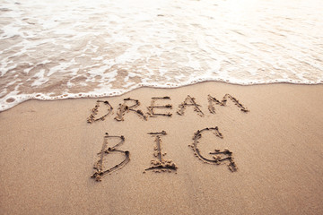 dream big, motivational sign on the sand of beach