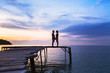 © Song_about_summer - beautiful romantic love background, silhouette of affectionate couple on the pier at sunset beach