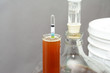 Home brew beer hydrometer with glass beer carboy in background