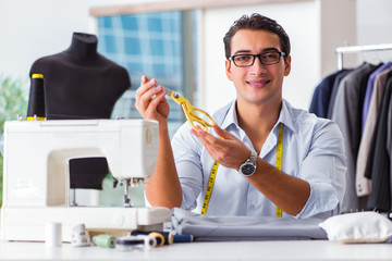 Young man tailor working on new clothing