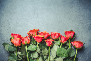 Red roses flowers on gray grunge surface.