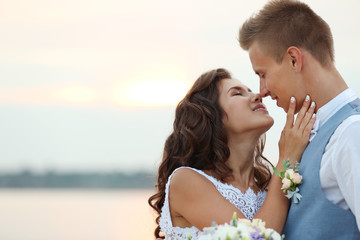 Wall Mural - Portrait of beautiful wedding couple near river, close up view