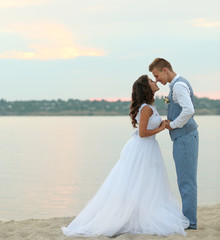 Wall Mural - Beautiful wedding couple near river