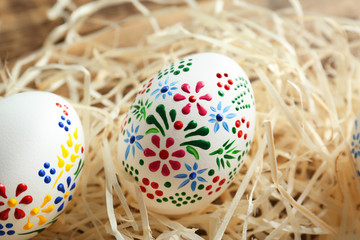 Wall Mural - Beautiful Easter eggs with floral ornament in decorative nest, closeup