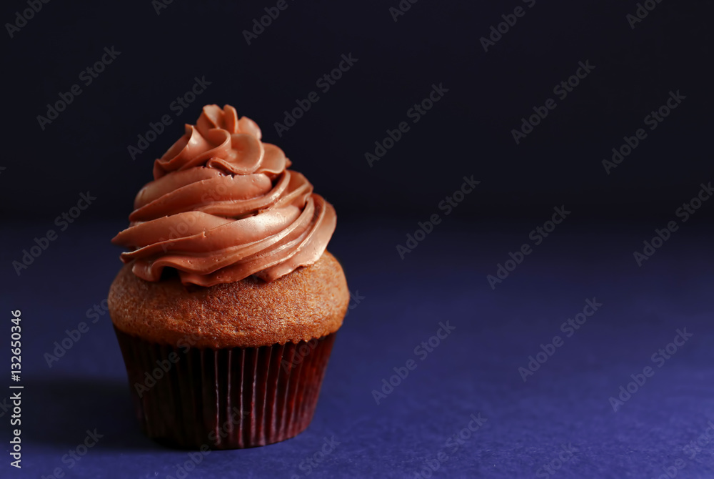 Tasty chocolate cupcake on dark background