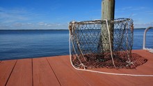 Empty Metal Crab Cage On Wooden Dock