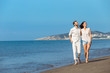 © FS-Stock - Couple walking on beach. Young happy interracial couple walking on beach smiling holding around each other.