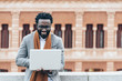 © santypan - Businessman using his laptop in the Street.