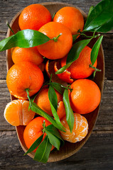 Poster - tangerines with green leaves  wooden background