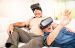 © Mirko Vitali - Senior couple having fun together with virtual reality headset - Retired people using new vr goggles glasses - New trends and technology concept - Focus on mature woman - Neutral apartment lights