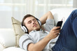 © Antonioguillem - Man sleeping listening music at home