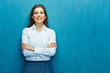 © Yuriy Shevtsov - Smiling young business woman against blue wall.