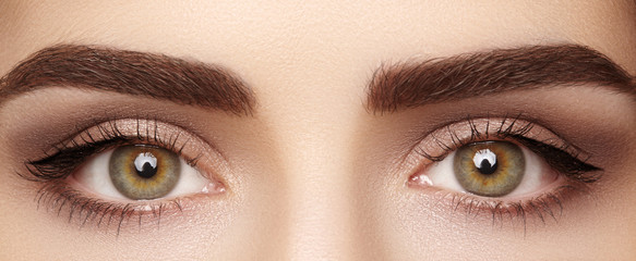 close-up macro of beautiful female eye with perfect shape eyebrows. clean skin, fashion naturel make
