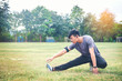 © joyfotoliakid - young handsome  jogger wearing fitness tracker stretching a leg