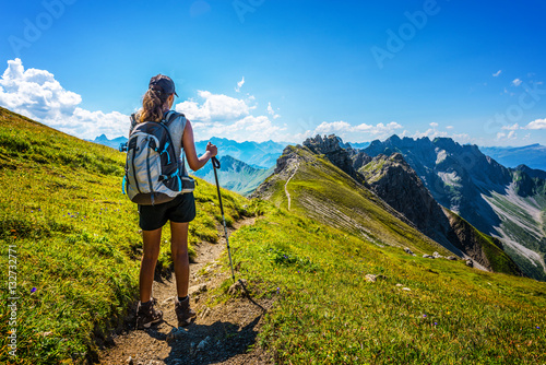 Fotografía Hiker in boots and backpack holds walking stick