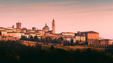 Fototapeta  - Bergamo Alta old town colored af sunset's lights - Lombardy Italy
