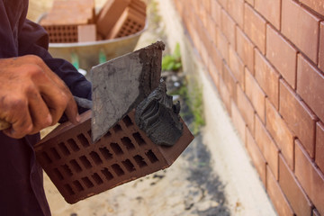 Bricklayer lays bricks under unravel. construction work