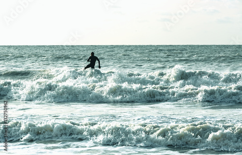 Fotografía Single alone surfer surfs in cold sea at English coast