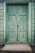 The Street Door Of The Old House With A Porch Painted In Green Color. Paint Became Old From Time