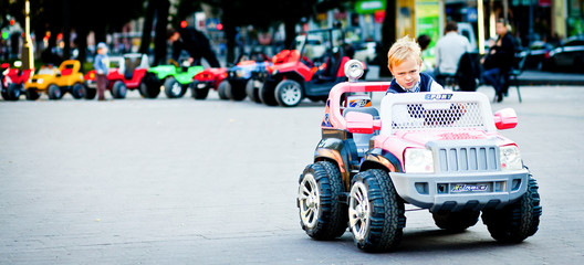 Wall Mural - You'd better don't do this! Boy on toy outlander drives to attac