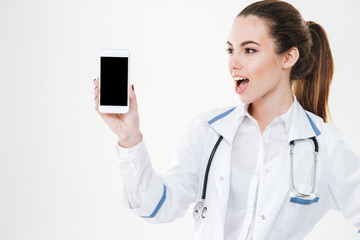 Sticker - Surprised woman doctor standing and holding blank screen cell phone