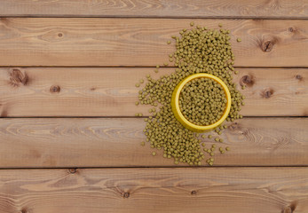 Cat food in bowl on wood background