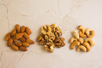 Three types of nuts to the diet on a marble background