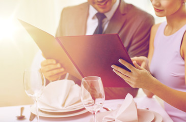 Canvas Print - close up of happy couple with menu at restaurant