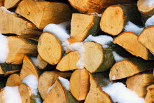 Stacked Firewood In Winter Under The Snow