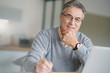 © goodluz - Senior man at home connected on laptop computer