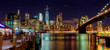 © ungvar - New York City Brooklyn Bridge and Manhattan skyline with skyscrapers over Hudson River illuminated  lights at dusk after sunset.
