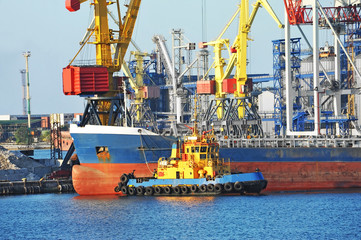 Tugboat assisting bulk cargo ship