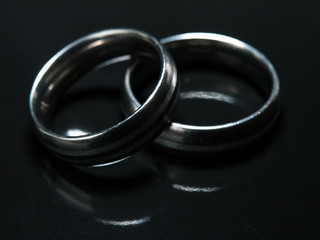 Two used wedding rings on black background