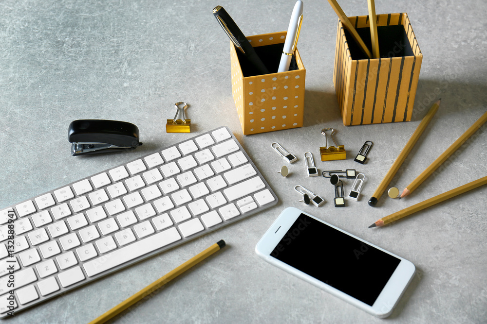 Workplace with keyboard, smart phone and golden stationery on light background