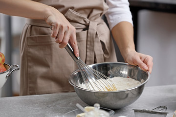 Canvas Print - Young woman making dough in kitchen, closeup