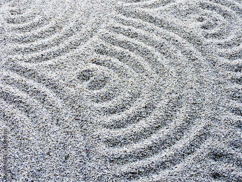 Fototapeta na wymiar Wavy sand pattern in Japanese rock garden