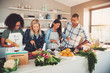 © Flamingo Images - Four mixed friends preparing a meal in kitchen