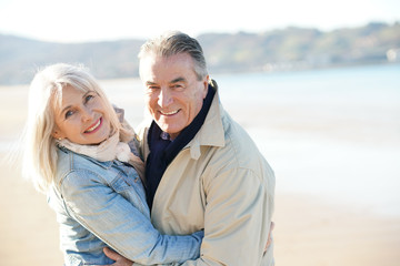 Wall Mural - Portrait of senior couple having fun at the beach, wintertime