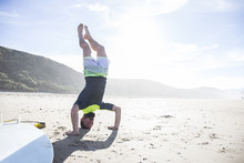 Man Doing A Headstand On The Beach
