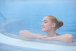 Young woman in outside thermal pool, relaxed